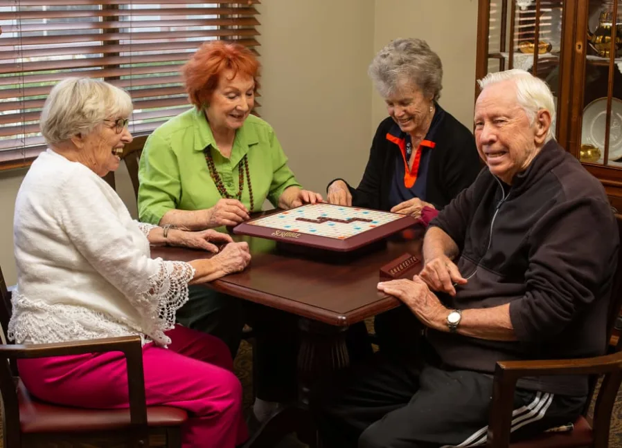 Seniors playing board games together in community room