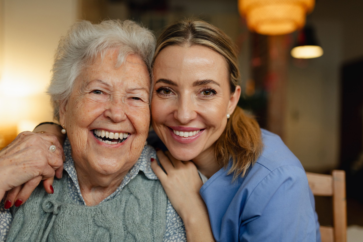 Caring caregiver with smiling senior resident at Gables of Ojai
